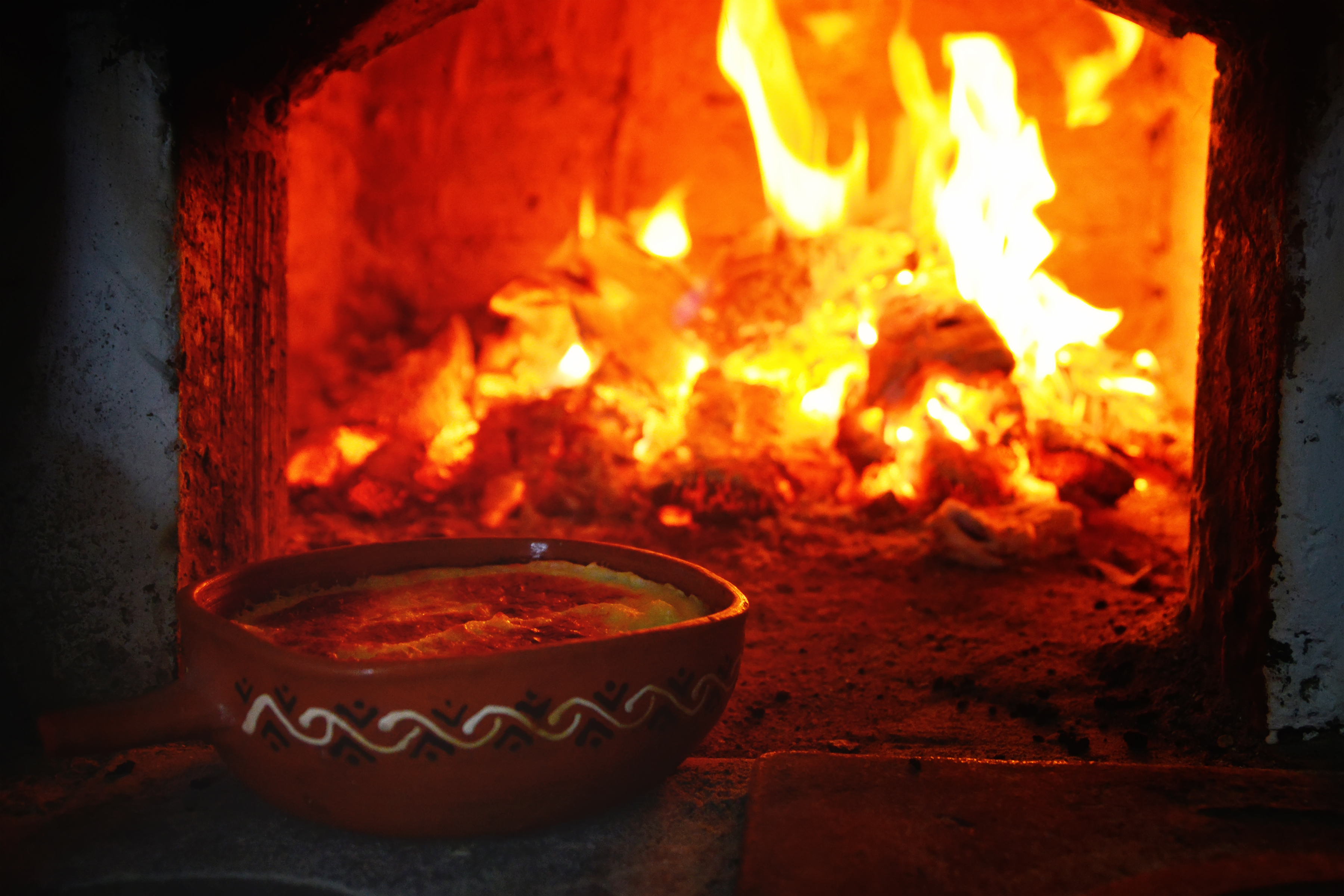37564075_l.png Porridge in a handmade and painted bowl in front of a brick oven with brightly burning logs