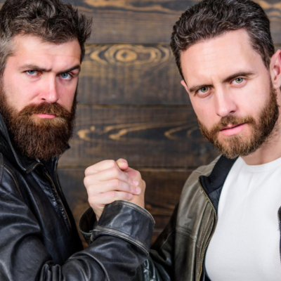 romeo22.png Two men clasping hands and looking at the camera