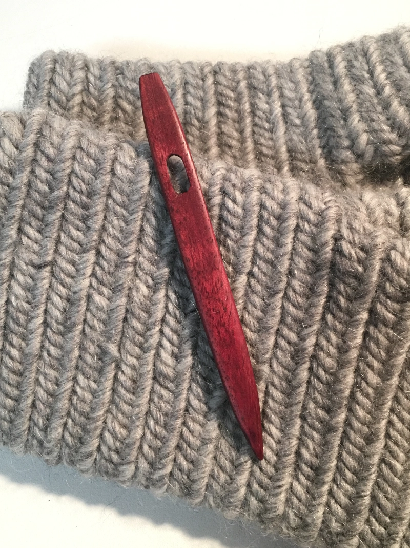 Red Heart Wood Nalbinding Needle on Mittens.webp Red Heart Wood Nalbinding Needle on Grey Mittens