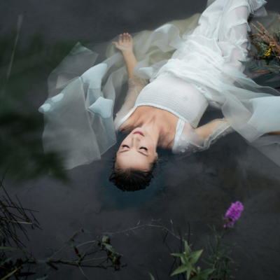 kriscole.png Woman in white dress floating in lake