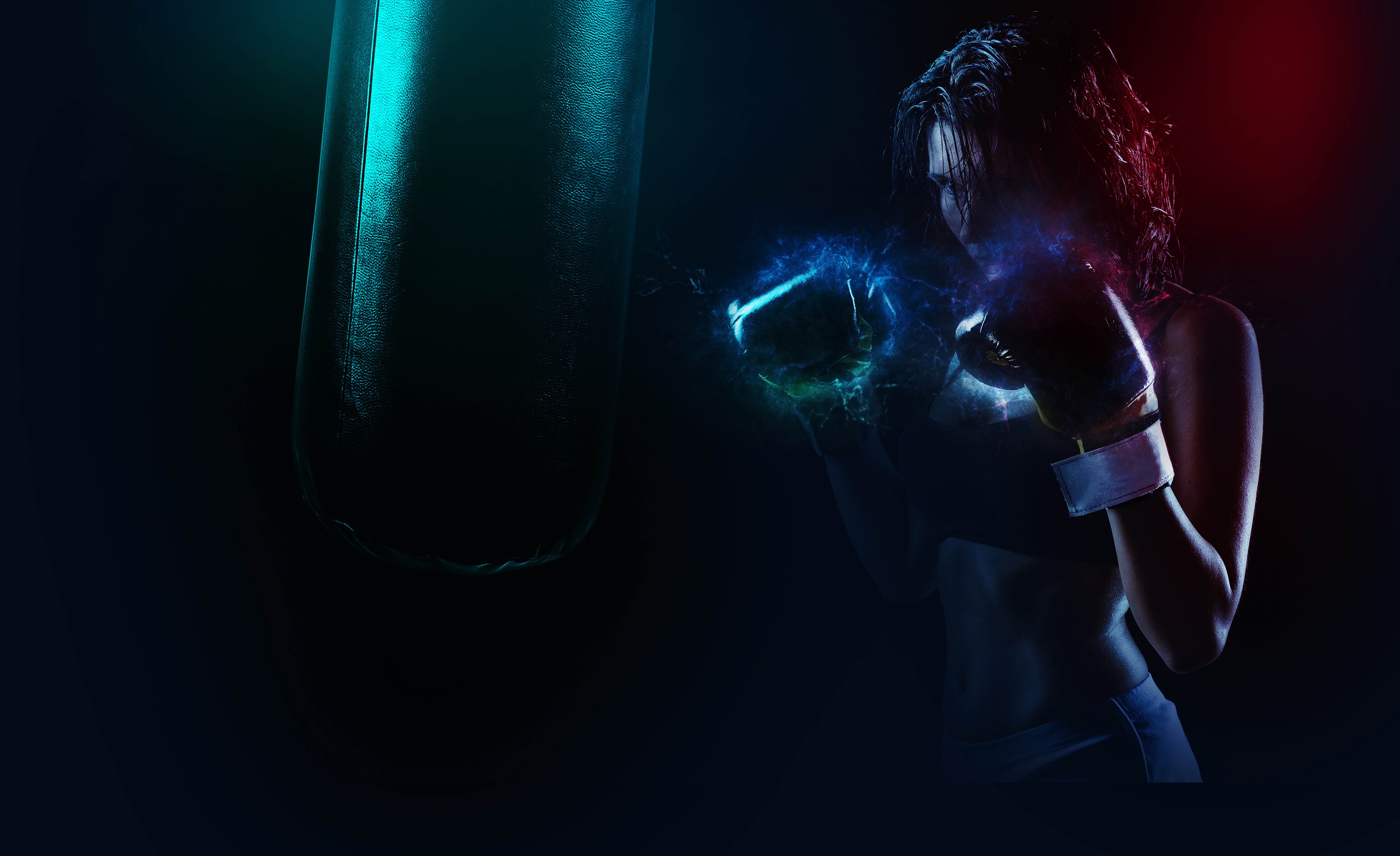 thedigitalartist-boxer.jpg A female boxer, glaring with intense focus at a punching bag, while energy forms around her gloved hands