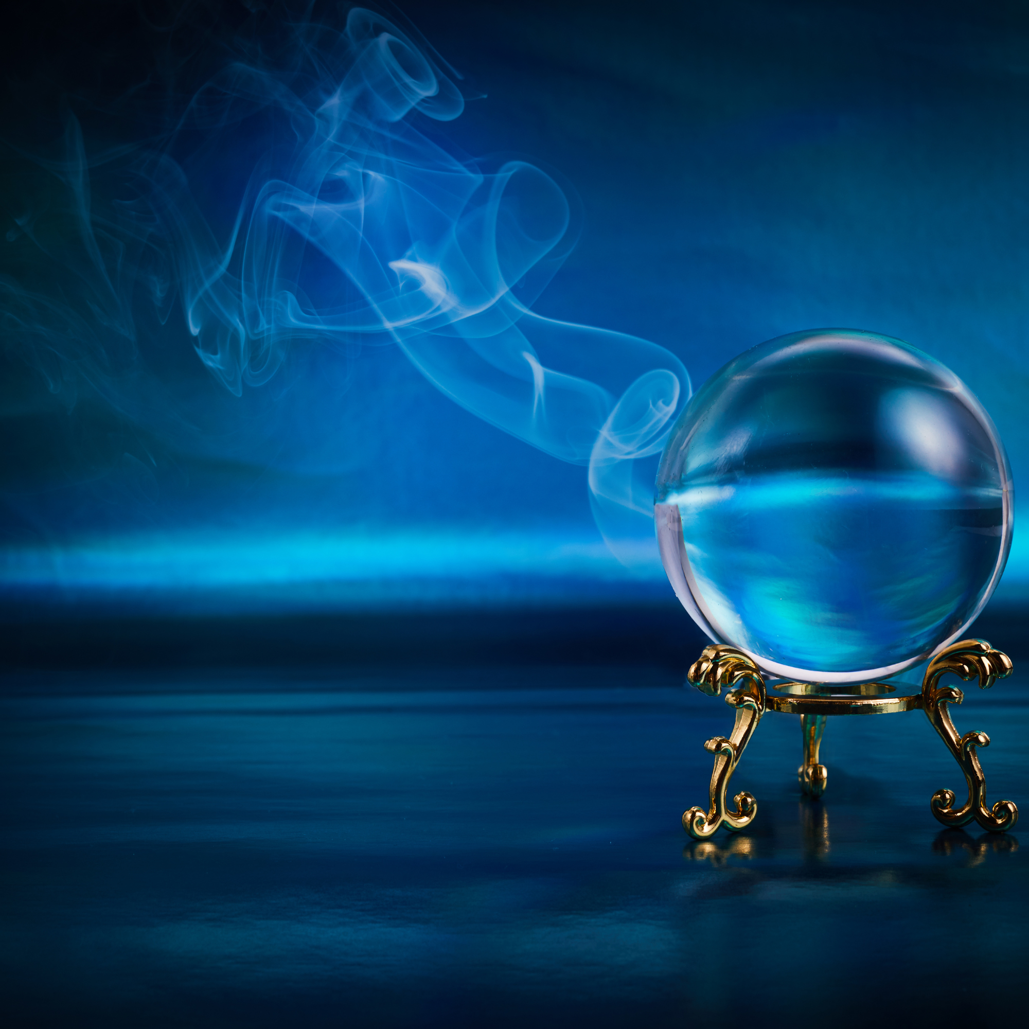 A crystal ball resting on a gold stand on the surface of still water, with the water reflecting in it, emitting mist