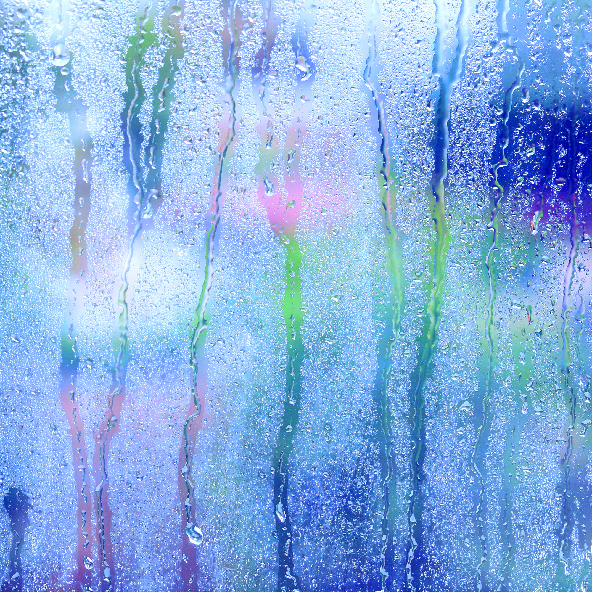 Rain streaking on a windowpane, with colourful pastels in the background