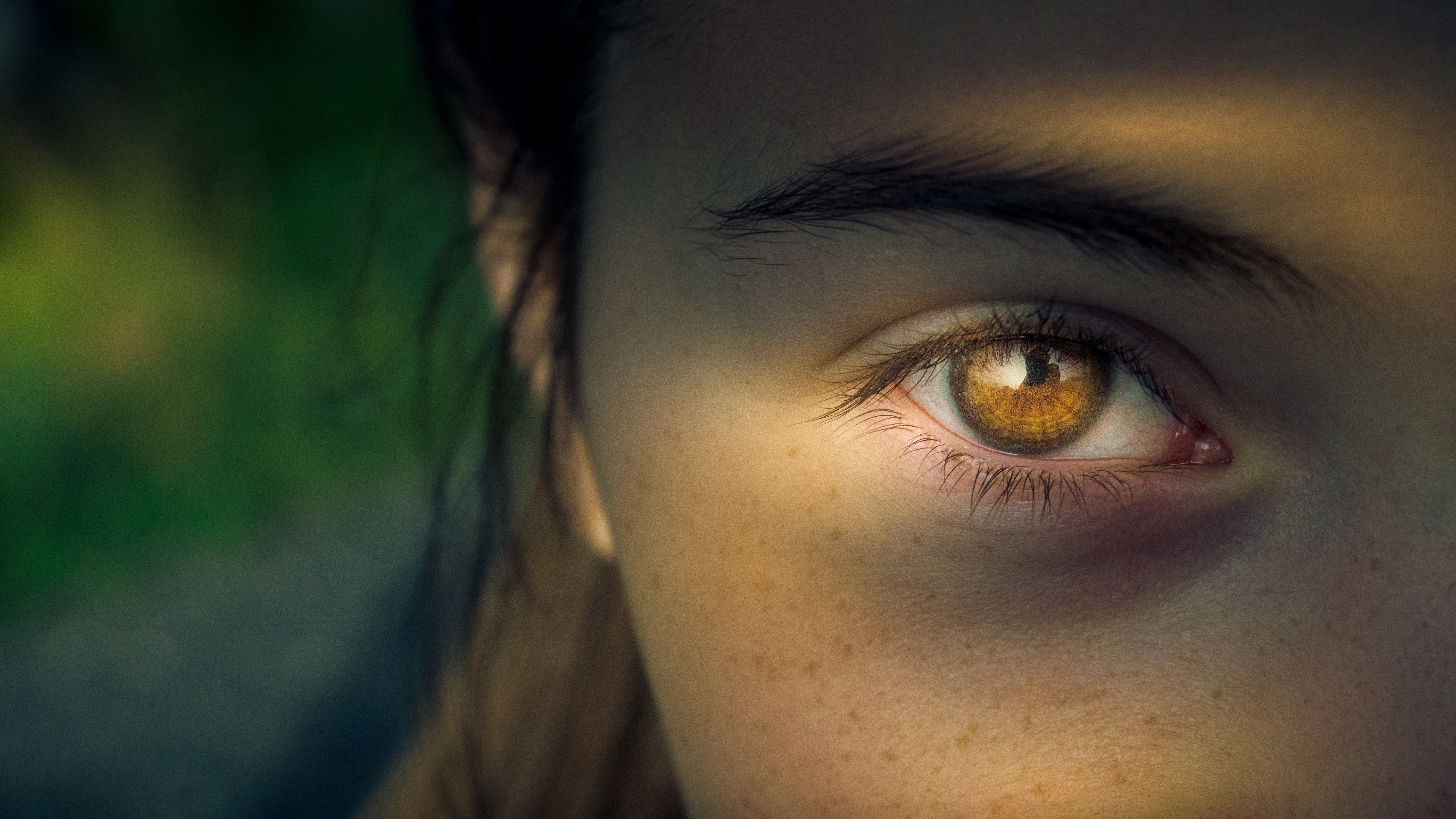 Belief-helmut_strasil.jpg A closeup of a woman's golden-brown eye, illuminated in sunlight and shadow, with an intensely focused expression