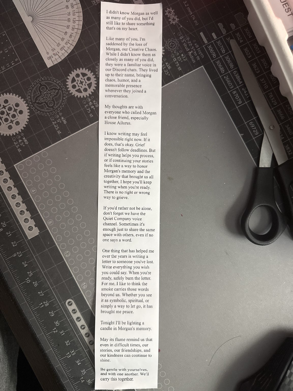 A photo of a printout of the above text against a craft mat with scissors on the right