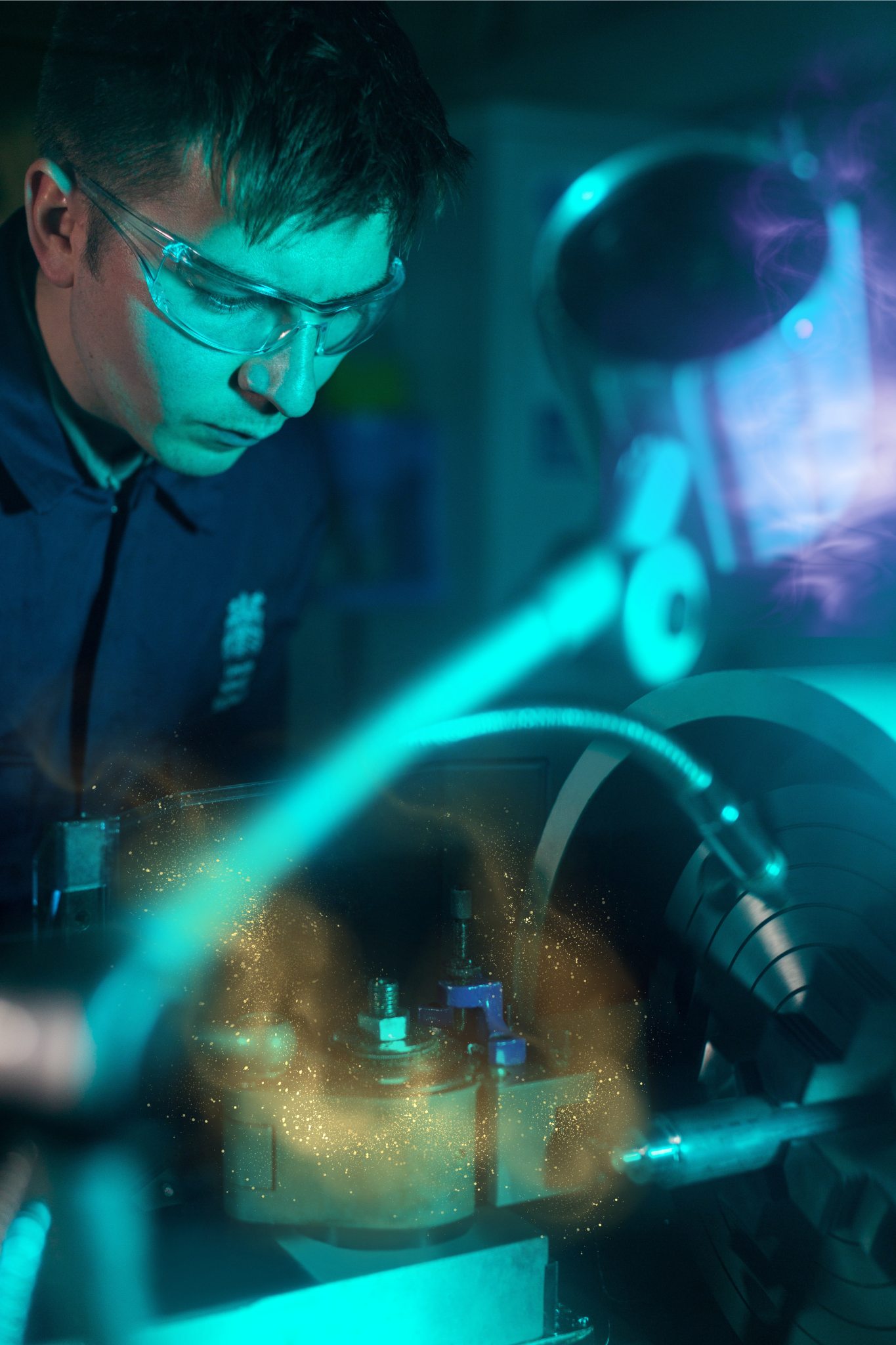 Mechanomancy.png A young man in protective goggles working with machining equipment that sparkles with gold magic