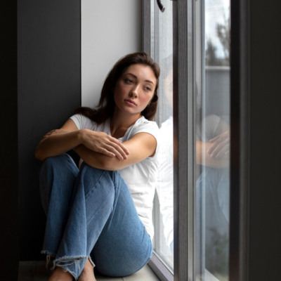 Magnific.png Sad woman looking out the window